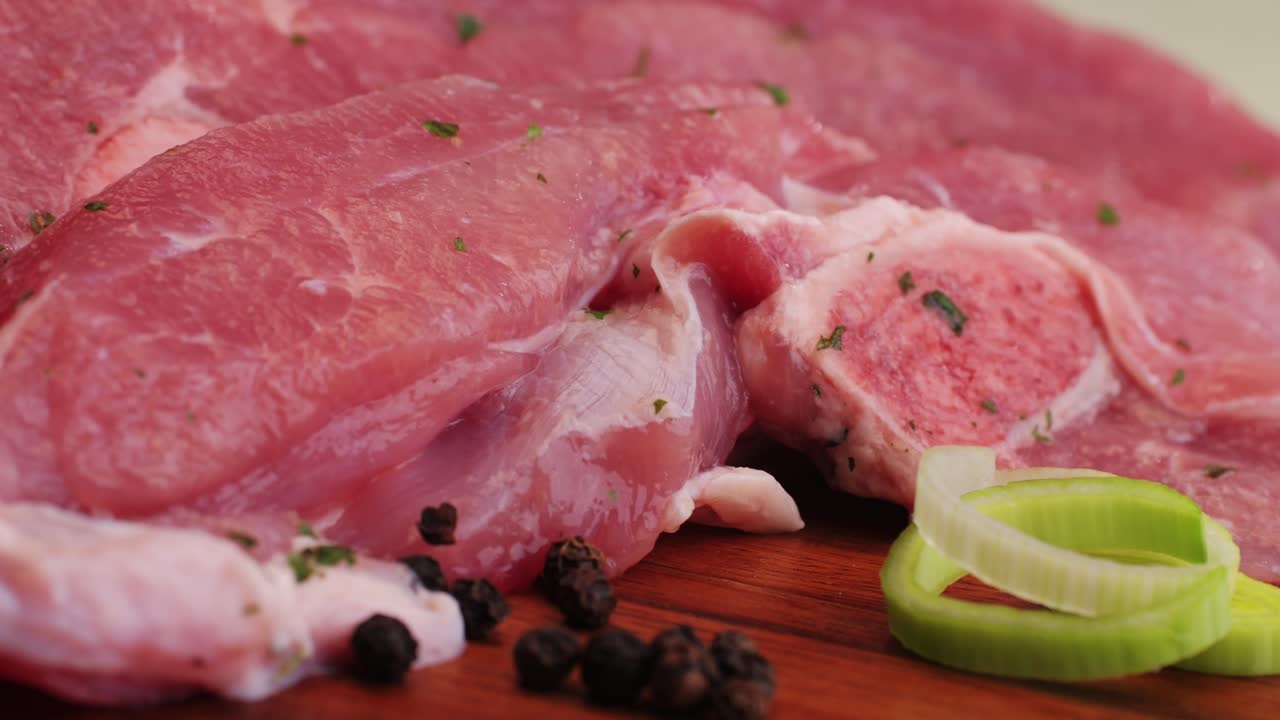 Raw slice beef meat in spices: paprika, salt, pepper, turmeric on plate close-up. Preparing raw food for cooking. Grill and Fry beef, pork, chicken, duck, turkey kebab with vegetables.