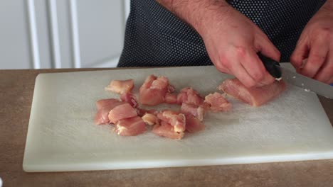 pollo en cubos en una tabla de cortar blanca 4