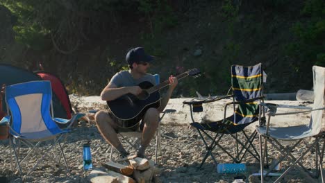 man playing guitar near riverside 4k