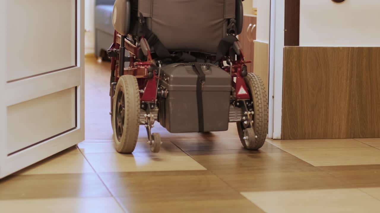 un hombre en silla de ruedas conduce por el pasillo. una persona con discapacidad se mueve por el hospital.