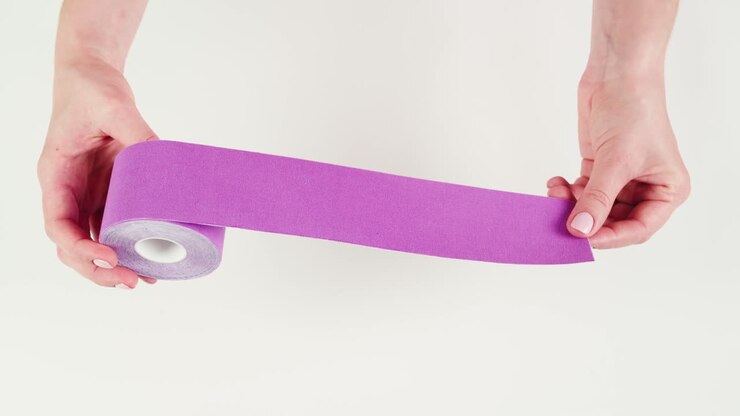 Kinesiology medical taping, doctor Physical therapist applying elastic surgical tape to patient body, treating injured knee young athlete.Post traumatic rehabilitation, sport physical therapy recovery