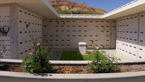 una toma aérea de un mausoleo de piedra con un jardín de flores en primer plano en una morgue de california