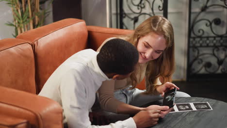 woman shows baby ultrasonic recording to black boyfriend