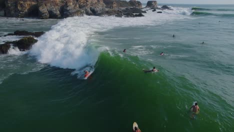 Vista-Panorámica-Aérea-De-Surfistas-Montando-Olas-En-Punta-Zicatela-Oaxaca-Iluminada-Por-El-Sol,-Costa-De-México