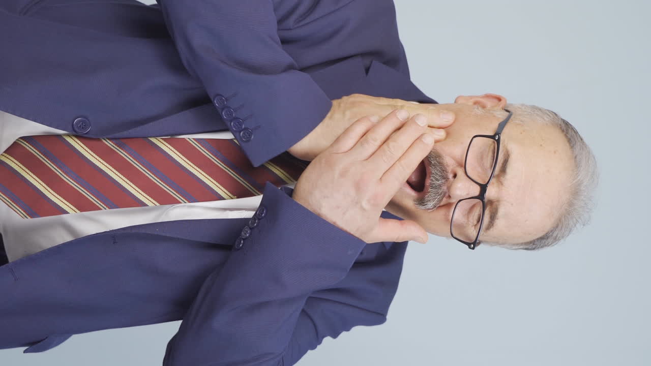 vídeo vertical de un viejo hombre de negocios que sufre de dolor de muelas.