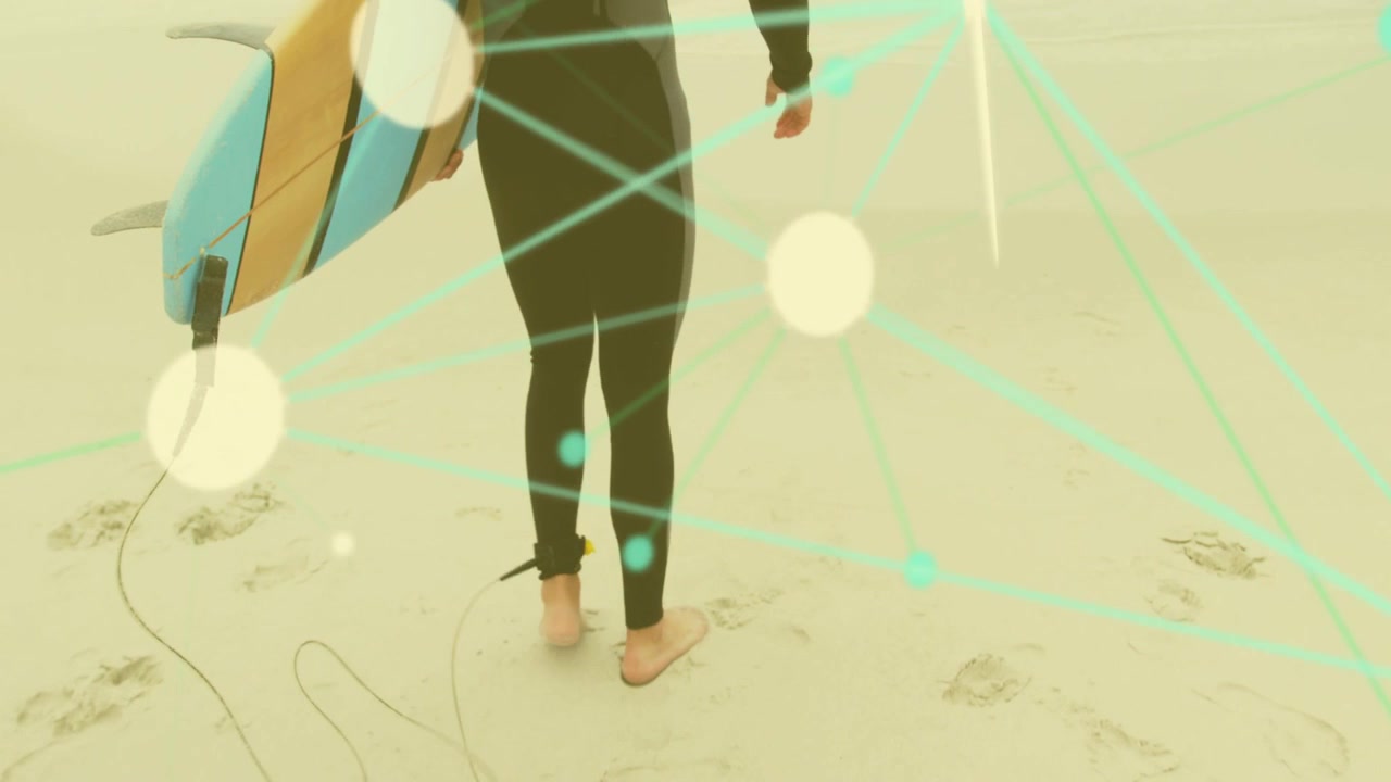 Surfista che cammina sulla sabbia bagnata, dirigendosi verso le onde, tenendo la tavola con il leash alla caviglia, con linee bokeh in movimento