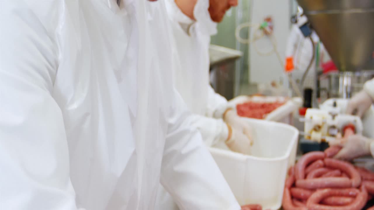 Butchers preparing sausage