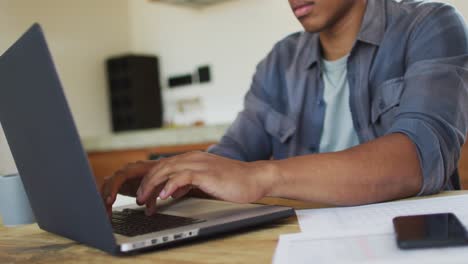 african american man working from home and using laptop