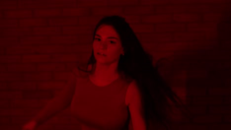 Female-dancer-in-a-dress-dancing-in-a-red-light