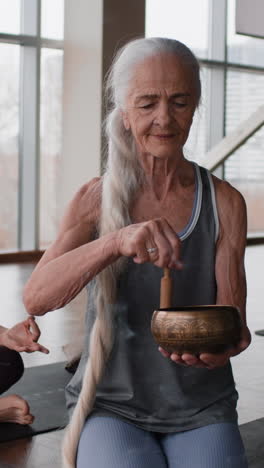 senior woman meditating with singing bowl