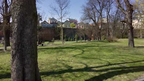 silencio de una pareja sentada en un banco del parque en un día soleado de primavera, en el fondo las murallas de la ciudad y los edificios de olomouc, república checa