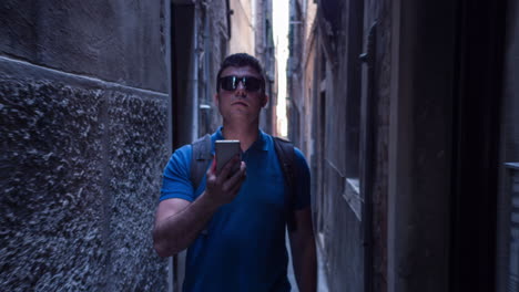 hombre usando el teléfono en un estrecho callejón veneciano