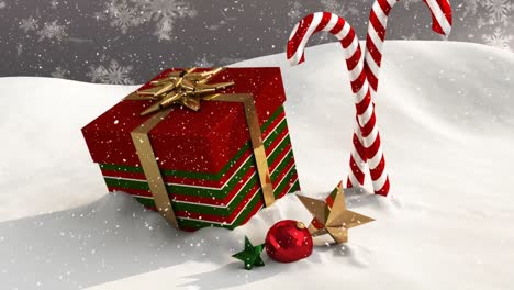 Animation-of-snow-falling-over-christmas-present,-candy-cane-and-decorations