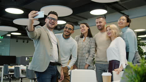 happy team taking selfie in modern office