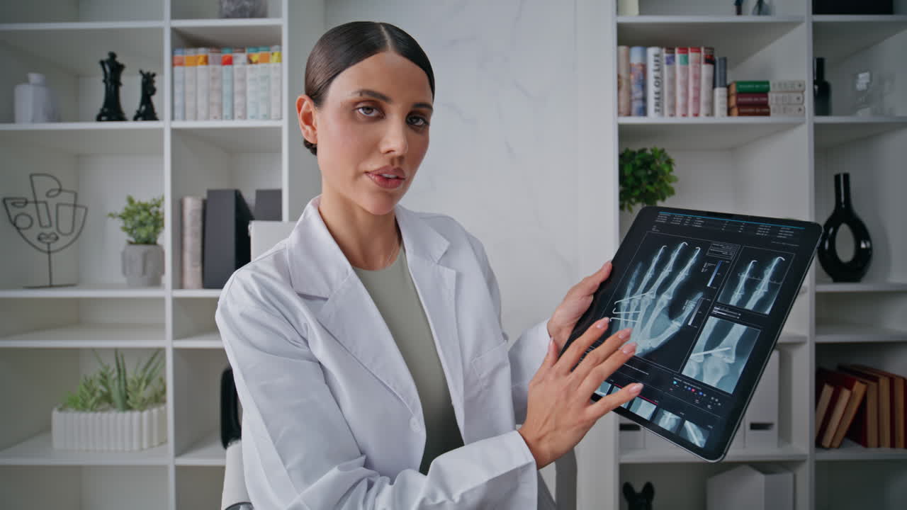 Remote doctor examining x-ray on tablet at video call in clinic pov video