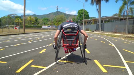 un niño con discapacidad conduciendo un handbike en una carrera de paraciclismo