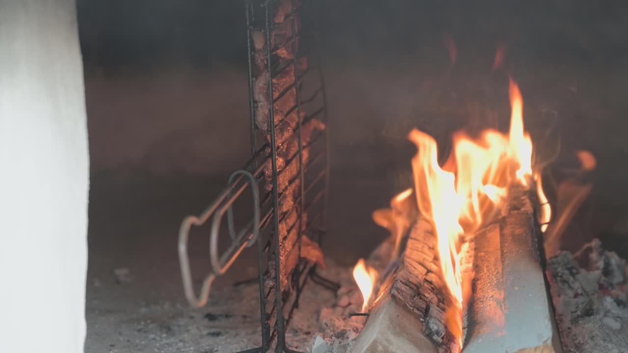 Close-up of beef chops grilling inside a traditional wood-fired oven