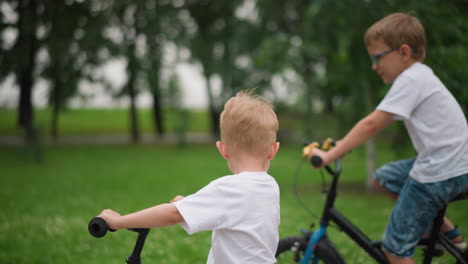 two brothers enjoy a joyful moment together as they ride their bicycles, the younger brother rides ahead, passing his older sibling