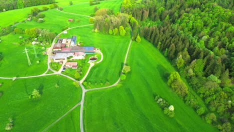 Drohne-Fliegt-über-Einen-Kleinen-Malerischen-Bauernhof-Mit-Grünen-Feldern