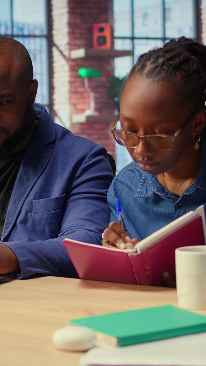 African American Business Colleagues Collaborating on Laptop and Taking Notes