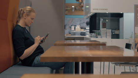 mujer en un café navegando por la web en su móvil