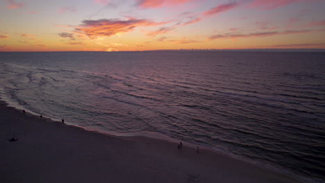 Idyllic-Sunset-View-Over-Seascape-With-People-Strolling