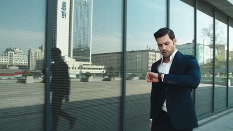 Closeup-man-checking-time-on-watch.-Business-man-going-upstairs-at-street