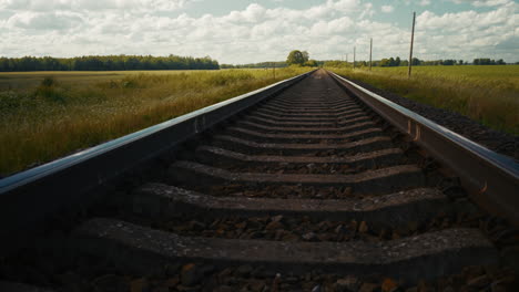 countryside train tracks under a cloudy sky