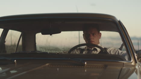 man driving a vintage car