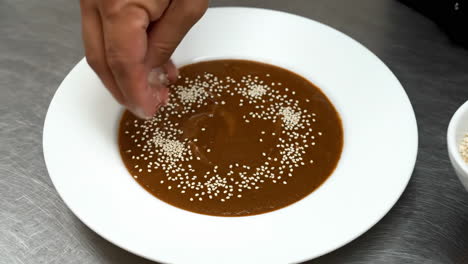 garnishing a dish with sesame seeds