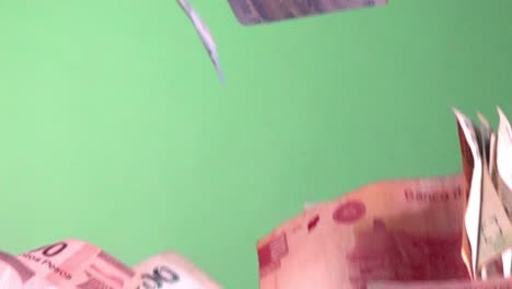 Slow-motion-shot-of-a-batch-of-bank-notes-falling-against-a-greenscreen-background