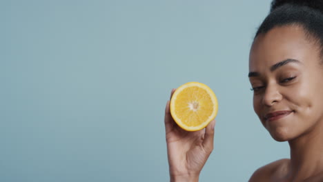 portrait attractive young african american woman holding lemon smiling enjoying natural healthy skincare essence beautiful female with perfect complexion on blue background