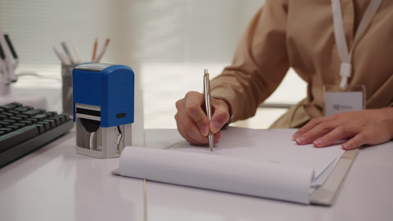 Hands of Office Worker Setting Seal to Document