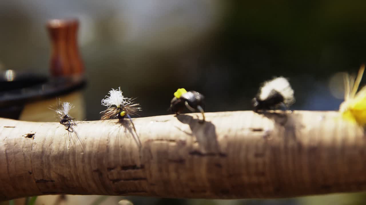 caña de pesca con mosca, carrete y gancho en roca