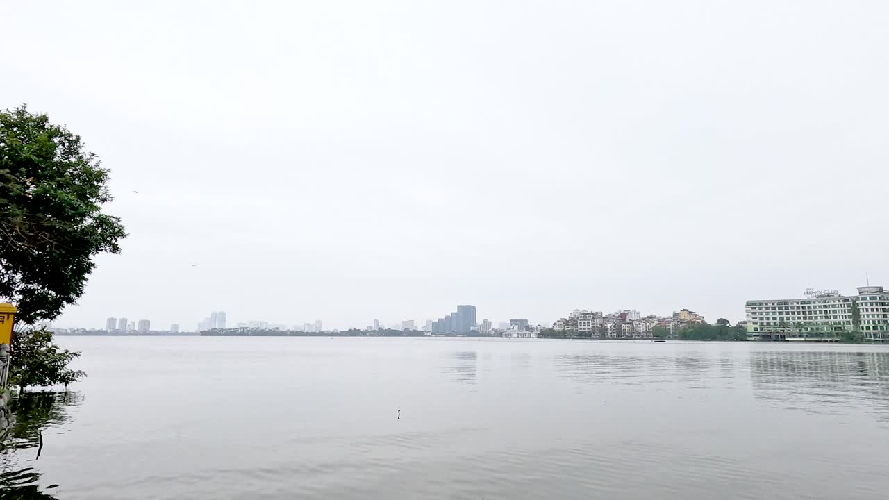 관광객들이 하노이의 강변에 있는 사원을 탐험합니다.