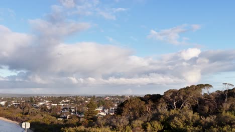 Aerial camera pans over Rye suburb, revealing houses, trees, and dramatic evening sky with clouds
