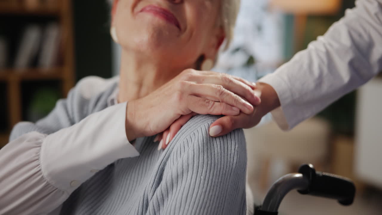 cuidador que apoya a una anciana en silla de ruedas