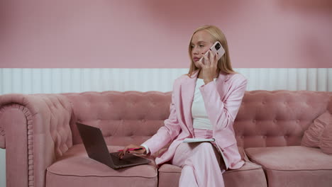 chica rubia haciendo una llamada y usando una computadora portátil