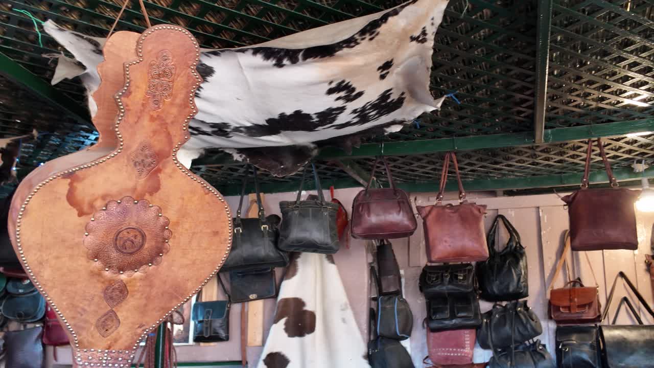 Chouara Tannery in Fes Medina, Morocco, showing colorful tanned leather goods hanging from walls and ceiling