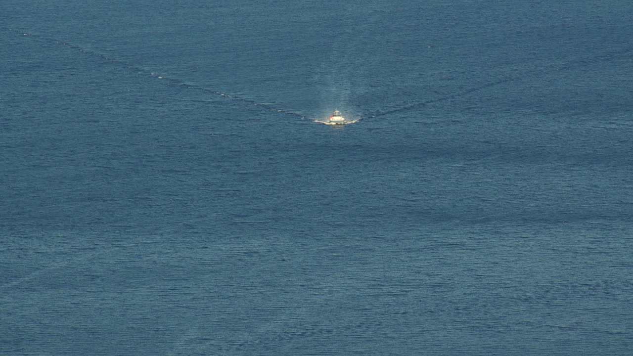 Long shot of a small boat entering the port of Bergen. Filmed from Fløyen Panorama