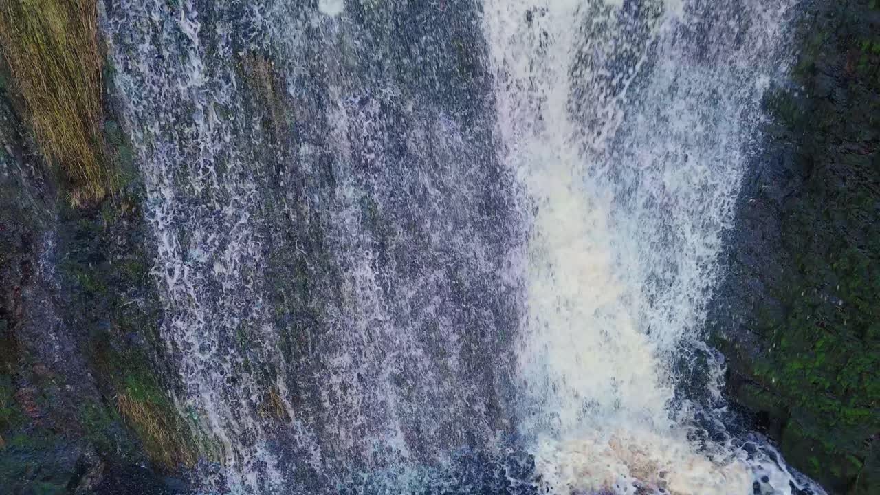 Aerial drone footage of a tall rocky waterfall in the Yorkshire Dales, Pennies