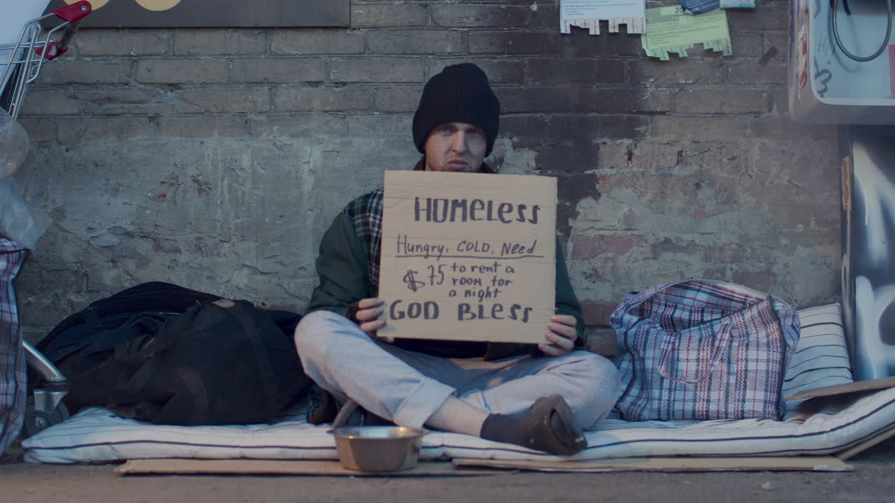 Portrait of Homeless Man Holding Sign Asking for Money to Rent Room