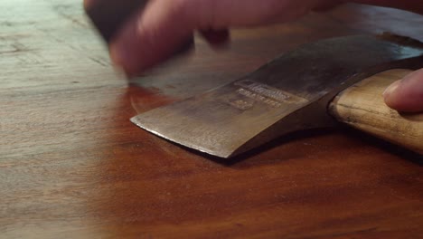 tool maintenance: rusty old axe is cleaned with fine grit sandpaper