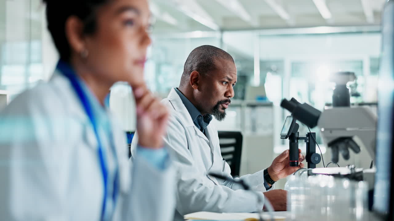 Scientists working in a laboratory with a microscope
