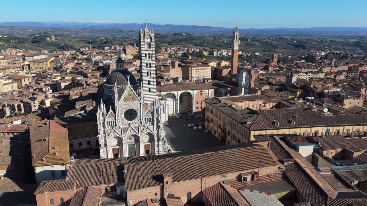Duomo di siena and historic cityscape under a clear blue sky, aerial view