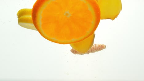 Vibrant-mixture-of-fruits-to-fight-cold-dropped-into-water,-close-up-view