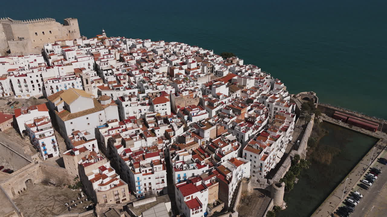 Aerial topdown over Peniscola castle and surrounding wall along coastline and sea cliffs