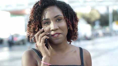 vista frontal de una mujer alegre hablando con un amigo por teléfono