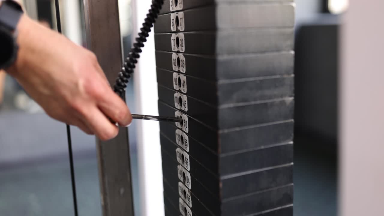 Weight plates being selected in a gym