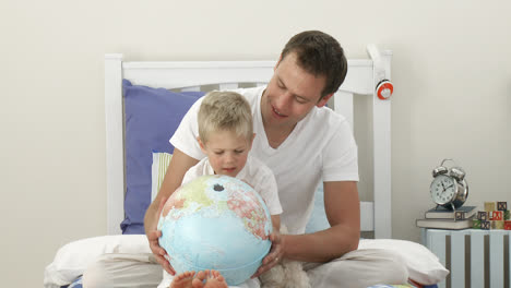 father and son looking at a terrestrial globe